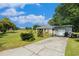 Inviting home featuring a long driveway and a detached garage, surrounded by lush greenery at 14285 Oconner Rd, Kathleen, FL 33849