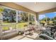 Inviting screened porch with a variety of seating options and views of the surrounding greenery at 14285 Oconner Rd, Kathleen, FL 33849