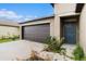 Close-up of a home's exterior with a two-car garage, front door, and small garden at 1700 Red Loop, Lakeland, FL 33801