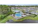 Aerial view of a community pool surrounded by lounge chairs, palm trees and a lake at 1700 Red Loop, Lakeland, FL 33801