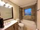 Cozy bathroom with shower and tub combination, neutral tile and a wood vanity at 231 4Th St, Winter Haven, FL 33880