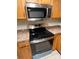 Close-up of the kitchen's microwave and stove with matching wood cabinetry at 231 4Th St, Winter Haven, FL 33880