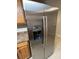 Close up of a stainless steel refrigerator in a kitchen with wood cabinets and tile flooring at 231 4Th St, Winter Haven, FL 33880