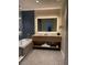 Well-appointed bathroom with a double vanity, soaking tub, and patterned accent wall at 3151 Sunset Walk Dr # 314, Kissimmee, FL 34747
