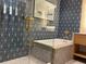 Elegant bathroom featuring a soaking tub, modern vanity, and striking blue-patterned accent wall at 3151 Sunset Walk Dr # 314, Kissimmee, FL 34747