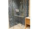 Modern bathroom shower with unique blue tile design and gold fixtures at 3151 Sunset Walk Dr # 314, Kissimmee, FL 34747