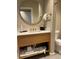 Bright bathroom with round mirror, quartz counters, and under sink towel storage at 3151 Sunset Walk Dr # 314, Kissimmee, FL 34747