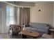 Bright living room featuring a comfortable gray couch and chair, with neutral colored walls and large windows at 3151 Sunset Walk Dr # 314, Kissimmee, FL 34747