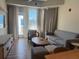 Comfortable living room with a sofa, chair, TV, and balcony access at 3151 Sunset Walk Dr # 314, Kissimmee, FL 34747