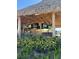 Tropical outdoor bar with multiple TVs, a thatched roof, and lush landscaping for relaxed entertainment at 3151 Sunset Walk Dr # 314, Kissimmee, FL 34747