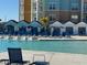 Resort-style pool with lounge chairs, cabanas, and colorful buildings in the background at 3151 Sunset Walk Dr # 314, Kissimmee, FL 34747