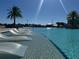 Relaxing zero-entry pool area with in-water loungers and palm trees at 3151 Sunset Walk Dr # 314, Kissimmee, FL 34747