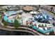 Aerial view of the community pool area with colorful water slides and play area, featuring nearby seating and landscaping at 168 Claffey Ct, Haines City, FL 33844