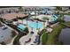 Aerial view of a community pool area with water slides, lounge chairs, and lush landscaping in a neighborhood setting at 168 Claffey Ct, Haines City, FL 33844