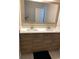 Bathroom vanity featuring double sinks with wood-look cabinets, a light countertop, and a large mirror at 168 Claffey Ct, Haines City, FL 33844