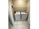 Compact laundry room with stacked washer and dryer and storage shelves at 168 Claffey Ct, Haines City, FL 33844