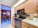 Cozy kitchen featuring wood cabinets, black appliances, and a sunny, floral wallpaper at 1743 Wilshire Ct, Lakeland, FL 33813