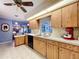 View of the kitchen with wood cabinets and a view into the living room with fireplace at 1743 Wilshire Ct, Lakeland, FL 33813