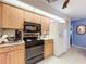 Bright kitchen features wood cabinets, black appliances, and a clean white refrigerator at 1743 Wilshire Ct, Lakeland, FL 33813