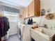 Well organized laundry room with washer, dryer, overhead cabinets and sink area at 1743 Wilshire Ct, Lakeland, FL 33813