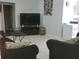 Comfortable living room with neutral walls, tile flooring, TV, and cozy furnishings for relaxation at 661 Crane Dr, Kissimmee, FL 34759