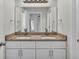 Bathroom featuring dual sink vanity, granite countertop, and vanity mirrors at 420 Tecumseh N Ave, Fort Meade, FL 33841