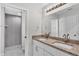 Bathroom with dual sink vanity, granite countertop, and a walk-in shower at 420 Tecumseh N Ave, Fort Meade, FL 33841