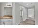 Hallway view of the bathroom with granite countertops, white cabinets, and plank flooring at 420 Tecumseh N Ave, Fort Meade, FL 33841