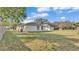 Side view of a single-story home with a white exterior, contrasting trim, and a well-kept lawn at 420 Tecumseh N Ave, Fort Meade, FL 33841