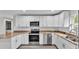 Kitchen with stainless steel appliances, white cabinets, subway tile backsplash, and stone countertops at 420 Tecumseh N Ave, Fort Meade, FL 33841