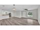 Spacious, open-concept living room showcasing hardwood floors, a modern ceiling fan, and ample natural light at 420 Tecumseh N Ave, Fort Meade, FL 33841