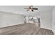 An open-concept living room with wood floors, a ceiling fan, and a view into the kitchen at 420 Tecumseh N Ave, Fort Meade, FL 33841