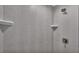 Close-up of a modern walk-in shower with grey tiling and built-in shelving at 420 Tecumseh N Ave, Fort Meade, FL 33841