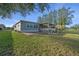 Backyard view with a patio area, steps, and well-maintained lawn at 1717 Lilly Ln, Lady Lake, FL 32159