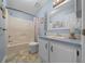 Well-lit bathroom features a tub with shower, toilet, and a sink with cabinet space at 1717 Lilly Ln, Lady Lake, FL 32159