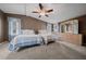 Bedroom showcasing two beds, ceiling fan and a well-lit dresser at 1717 Lilly Ln, Lady Lake, FL 32159