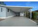 Carport with painted floor and storage that leads to a cozy outdoor seating area at 1717 Lilly Ln, Lady Lake, FL 32159
