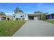 Charming single-story home featuring a spacious driveway and covered carport with a neatly maintained lawn at 1717 Lilly Ln, Lady Lake, FL 32159