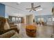 Spacious open-concept living area with wood floors, lots of light, ceiling fan, and comfortable seating at 1717 Lilly Ln, Lady Lake, FL 32159