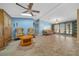Comfortable living room with ceiling fan, built-in shelving, and lots of natural light at 1717 Lilly Ln, Lady Lake, FL 32159