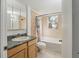 A tiled bathroom features a single sink vanity, toilet, and tub with shower at 3925 Ne 92Nd Pl, Anthony, FL 32617