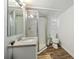 A bathroom features a shower, toilet, sink and wood-look flooring at 3925 Ne 92Nd Pl, Anthony, FL 32617
