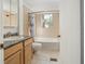 A tiled bathroom features a single sink vanity, toilet, and tub with shower at 3925 Ne 92Nd Pl, Anthony, FL 32617