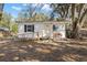 Charming single-story home featuring a front ramp, white siding, and mature trees at 3925 Ne 92Nd Pl, Anthony, FL 32617