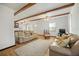 Living room with exposed wood beams, hardwood floors, and seamless access to the kitchen at 3925 Ne 92Nd Pl, Anthony, FL 32617