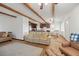 Open-concept floor plan showcasing wood beams, hardwood flooring, and access to the kitchen at 3925 Ne 92Nd Pl, Anthony, FL 32617