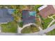 Aerial view showcasing the home's layout, including the screened-in pool, driveway, and surrounding green space at 12 Lake Link Dr, Winter Haven, FL 33884