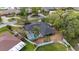 Aerial view of a lovely single-Gathering home with a screened pool and fenced yard nestled in a lush, green neighborhood at 12 Lake Link Dr, Winter Haven, FL 33884