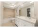 Bathroom with double sink vanity, neutral tile, and a large mirror, providing ample space at 12 Lake Link Dr, Winter Haven, FL 33884