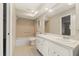 Bright bathroom featuring dual sinks, a tub with a shower, and a large mirror at 12 Lake Link Dr, Winter Haven, FL 33884